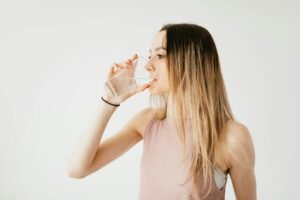 Chica bebiendo agua tratada con ósmosis